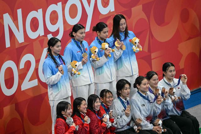 Silver medallists Japan's Rio Suzuki, Waka Kobori, Ruka Takezawa and Yui Fukuoka, gold medallists China's Li Jiaping, Liu Yaxin, Yu Yiting and Li Bingjie and bronze medallists South Korea's Jo Hyun-ju, Hur Yeon-kyung, Han Da-kyung and Lee Song-eun pose on the podium during the victory ceremony of the women's 4 x 200m freestyle relay swimming event during the 2026 Asian Games at the Tokyo Aquatics Centre in Tokyo on September 24, 2026. (Photo by ANDREW CABALLERO-REYNOLDS / AFP)
