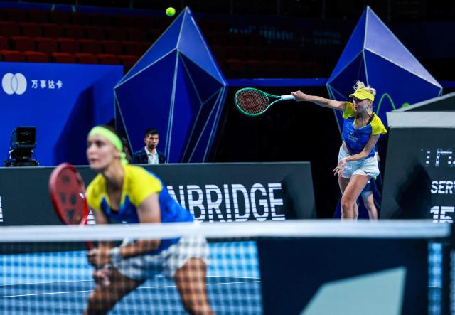 Ukraine's Lyudmyla Kichenok (R) serves next to Anhelina Kalinina (L) to Belgium's Magali Kempen and Lara Salden during their women's doubles quarter-final match at the Billie Jean King Cup tennis tournament in Shenzhen, southern China's Guangdong province on September 24, 2026. (Photo by CN-STR / AFP) / China OUT
