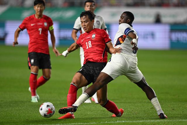 South Korea's Oh Hyeong-yu (C) fights for the ball with Ecuador's Willian Pacho (R) during the friendly football match between South Korea and Ecuador in Suwon on September 24, 2026. (Photo by Jung Yeon-je / AFP)