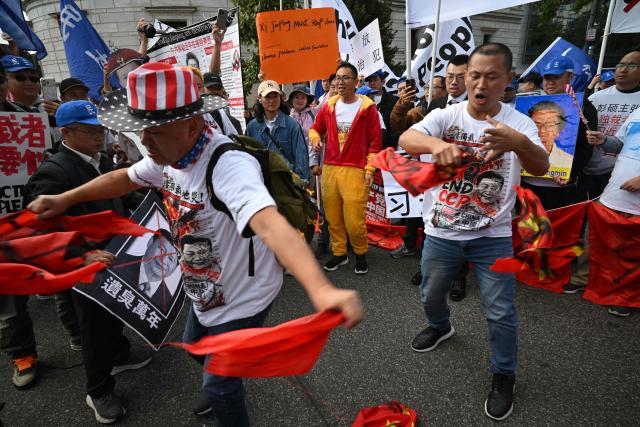 Demonstrators deface a Chinese flag during a protest against Chinese President Xi Jinping during his state visit in Washington, DC, on September 24, 2026. President Xi is on a State visit to the United States from September 23 to 25. (Photo by Mandel NGAN / AFP)