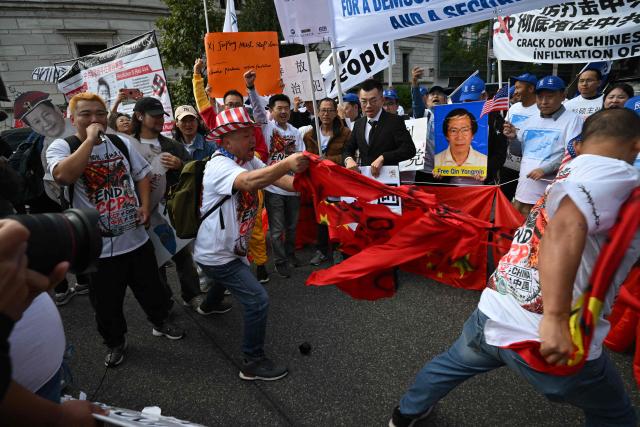 Demonstrators deface a Chinese flag during a protest against Chinese President Xi Jinping during his state visit in Washington, DC, on September 24, 2026. President Xi is on a State visit to the United States from September 23 to 25. (Photo by Mandel NGAN / AFP)