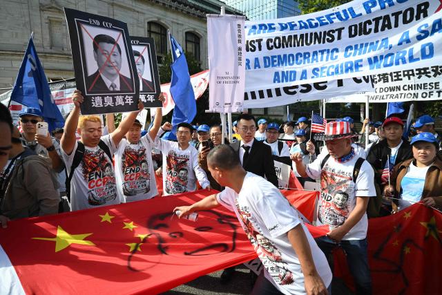 Demonstrators deface a Chinese flag during a protest against Chinese President Xi Jinping during his state visit in Washington, DC, on September 24, 2026. President Xi is on a State visit to the United States from September 23 to 25. (Photo by Mandel NGAN / AFP)