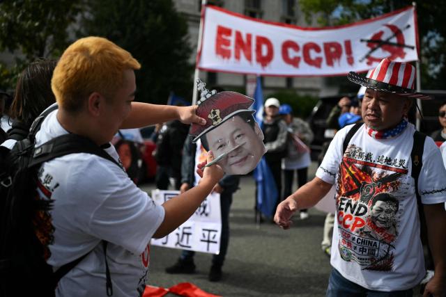 Demonstrators deface a poster depicting Chinese President Xi during a protest against his state visit in Washington, DC, on September 24, 2026. President Xi is on a State visit to the United States from September 23 to 25. (Photo by Mandel NGAN / AFP)