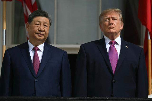 (L/R) China's President Xi Jinping and US President Donald Trump stand on the Blue Room balcony of the White House to watch an exhibition of the US Marine Corps Silent Drill Platoon, in Washington, DC, on September 24, 2026. President Xi is on a State visit to the United States from September 23 to 25. (Photo by SAUL LOEB / AFP)