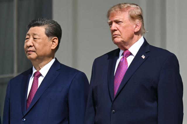 (L/R) China's President Xi Jinping and US President Donald Trump stand on the Blue Room balcony of the White House to watch an exhibition of the US Marine Corps Silent Drill Platoon, in Washington, DC, on September 24, 2026. President Xi is on a State visit to the United States from September 23 to 25. (Photo by SAUL LOEB / AFP)