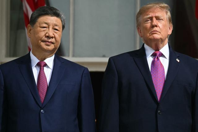 (L/R) China's President Xi Jinping and US President Donald Trump stand on the Blue Room balcony of the White House to watch an exhibition of the US Marine Corps Silent Drill Platoon, in Washington, DC, on September 24, 2026. President Xi is on a State visit to the United States from September 23 to 25. (Photo by SAUL LOEB / AFP)