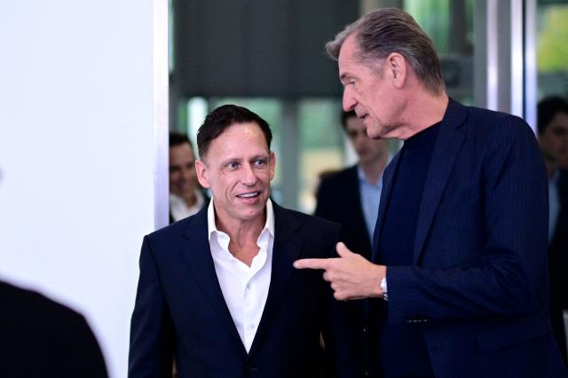 German-US entrepreneur, venture capitalist and conservative political activist Peter Thiel (L) is welcomed by CEO of media group Axel Springer SE Mathias Doepfner as he arrives on the red carpet for the Axel Springer Award in Berlin on September 24, 2026. (Photo by Tobias SCHWARZ / AFP)