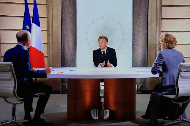 A photo shows a monitor as France's President Emmanuel Macron (C) speaks during an interview with France 2 journalist Caroline Roux (R) and TF1 journalist Gilles Bouleau (L) at the Elysee Presidential Palace, in Paris on September 24, 2026. The interview is broadcasted live on both French TV channels TF1 and France 2. (Photo by Ludovic MARIN / AFP)