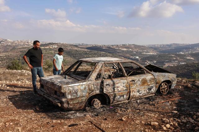Palestinians inspect a burnt car after it was allegedly torched by Israeli settlers in Atara village, north of Ramallah in the Israeli-occupied West Bank on September 24, 2026. Violence has surged in the West Bank, occupied by Israel since 1967, after Hamas's October 2023 attack sparked the war in Gaza. Recent months have seen soaring attacks by Israeli settlers against Palestinians, often with little or no legal consequence. (Photo by Zain JAAFAR / AFP)