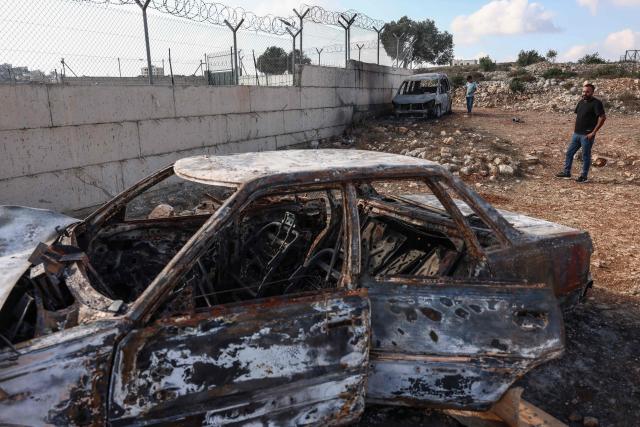 Palestinians inspect burnt vehicles after they were allegedly torched by Israeli settlers in Atara village, north of Ramallah in the Israeli-occupied West Bank on September 24, 2026. Violence has surged in the West Bank, occupied by Israel since 1967, after Hamas's October 2023 attack sparked the war in Gaza. Recent months have seen soaring attacks by Israeli settlers against Palestinians, often with little or no legal consequence. (Photo by Zain JAAFAR / AFP)