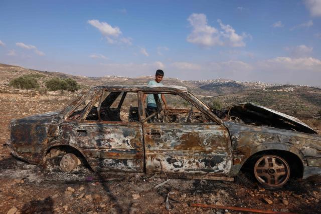 A Palestinian boy inspects a burnt car after it was allegedly torched by Israeli settlers in Atara village, north of Ramallah in the Israeli-occupied West Bank on September 24, 2026. Violence has surged in the West Bank, occupied by Israel since 1967, after Hamas's October 2023 attack sparked the war in Gaza. Recent months have seen soaring attacks by Israeli settlers against Palestinians, often with little or no legal consequence. (Photo by Zain JAAFAR / AFP)