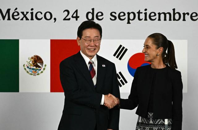 Mexico's President Claudia Sheinbaum and South Korea's President Lee Jae Myung shake hands during a briefing after a welcome ceremony at Palacio Nacional in Mexico City, on September 24, 2026. (Photo by Yuri CORTEZ / AFP)