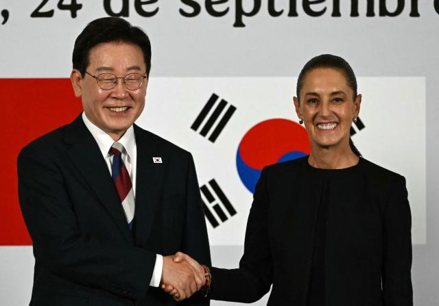 Mexico's President Claudia Sheinbaum and South Korea's President Lee Jae Myung shake hands during a briefing after a welcome ceremony at Palacio Nacional in Mexico City, on September 24, 2026. (Photo by Yuri CORTEZ / AFP)