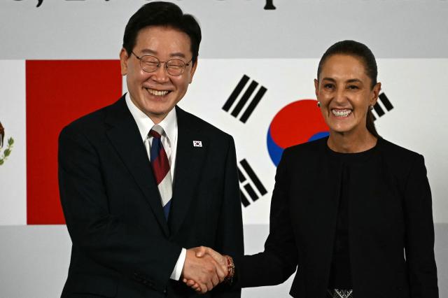 Mexico's President Claudia Sheinbaum and South Korea's President Lee Jae Myung shake hands during a briefing after a welcome ceremony at Palacio Nacional in Mexico City, on September 24, 2026. (Photo by Yuri CORTEZ / AFP)