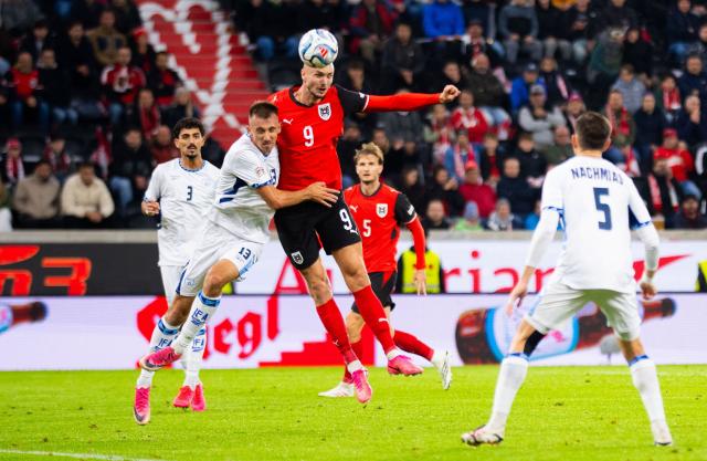 Israel's defender #13 Nikita Stoinov (L) and Austria's forward #09 Sasa Kalajdzic jump for the ball during the UEFA Nations League Group B3 football match between Austria and Israel in Linz, Austria on September 24, 2026. (Photo by GEORG HOCHMUTH / APA / AFP) / Austria OUT