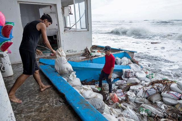 Residents place sandbags as a protective barrier against strong waves generated by Hurricane Polo at Playa Azul in Lazaro Cardenas, Michoacan state, Mexico on September 24, 2026. Hurricane Polo strengthened to the highest category on September 22 in the Mexican Pacific, with no forecast of making landfall but with heavy rainfall expected. Polo intensified from Category 1 to Category 5 on the Saffir-Simpson scale in less than 24 hours. (Photo by Enrique CASTRO / AFP)