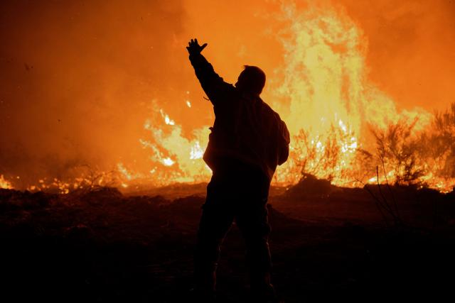 Spain's firefighters and residents attempt to extinguish a forest fire near the hamlet of Baltar, close to the town of Xinzo de Limia in the north-west of Spain on September 24, 2026. The blaze has burned more than 140 hectares. Eight helicopters and nine aircraft were deployed alongside ground crews. (Photo by Adrian Irago / AFP)