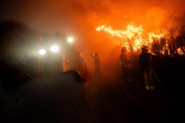 Spain's firefighters and residents attempt to extinguish a forest fire near the hamlet of Baltar, close to the town of Xinzo de Limia in the north-west of Spain on September 24, 2026. The blaze has burned more than 140 hectares. Eight helicopters and nine aircraft were deployed alongside ground crews. (Photo by Adrian Irago / AFP)