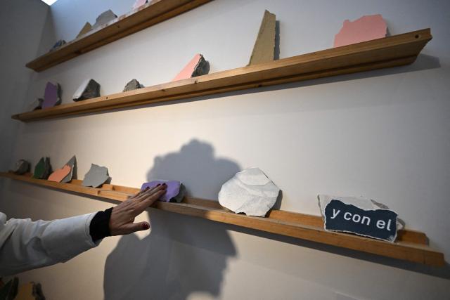 Museum curator Rosa Angel Arenas interacts with the installation "Pedazo de museo", composed of fragments from the Pereira Art Museum building damaged in a recent earthquake, during the ARTBO International Art Fair in Bogota on September 24, 2026. (Photo by Raul ARBOLEDA / AFP)
