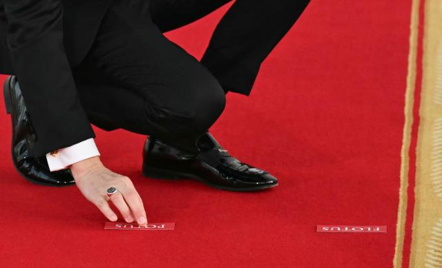 A White House aide places position markers for US President Donald Trump and First Lady Melania Trump ahead of a photo opportunity with , Chinese President Xi Jinping and his wife Peng Liyuan on the North Portico steps before a state dinner at the White House in Washington, DC, on September 24, 2026. President Xi is on a State visit to the United States from September 23 to 25. (Photo by SAUL LOEB / AFP)