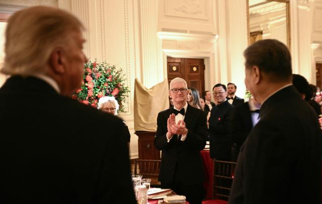Apple Chairman Tim Cook (C) applauds as US President Donald Trump (L) and Chinese President Xi Jinping (R) arrive for a state dinner at the White House in Washington, DC, on September 24, 2026. President Xi is on a State visit to the United States from September 23 to 25. (Photo by Brendan SMIALOWSKI / AFP)