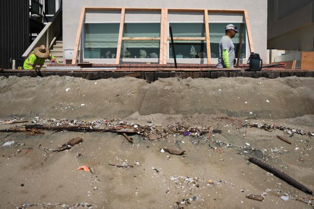 Workers repair a home along the boardwalk that was damaged by previous storms as residents prepare for elevated surf, coastal flooding and beach erosion ahead of Hurricane Polo in Long Beach, California, on September 24, 2026. On September 21, California's governor declared a state of emergency as the US west coast readies for what is expected to be a damaging El Nino. Forecasters say the coming months could bring powerful and damaging storms to the region because of this weather pattern, with the threat of higher-than-usual tides that could trigger coastal flooding. (Photo by Patrick T. Fallon / AFP)