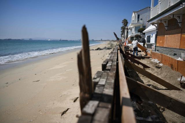 A worker repairs a home along the boardwalk that was damaged by previous storms as residents prepare for elevated surf, coastal flooding and beach erosion ahead of Hurricane Polo in Long Beach, California, on September 24, 2026. On September 21, California's governor declared a state of emergency as the US west coast readies for what is expected to be a damaging El Nino. Forecasters say the coming months could bring powerful and damaging storms to the region because of this weather pattern, with the threat of higher-than-usual tides that could trigger coastal flooding. (Photo by Patrick T. Fallon / AFP)