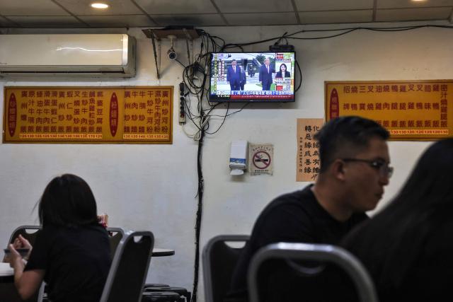 People dine as a television broadcasts news of US President Donald Trump meeting Chinese President Xi Jinping, at a restaurant in Taipei on September 25, 2026 (Photo by I-Hwa Cheng / AFP)