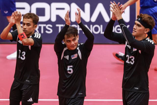 (L-R) Malaysia's captain Farhan Adam, Malaysia's Mohamad Azlan Alias and Malaysia's Mohammad Syahir Mohd Rosdi celebrate wining the first round match during the men's team regu sepak takraw gold medal finals between Thailand and Malaysia at Nagoya City Mizuho Park Gymnasium in Nagoya on September 25, 2026. (Photo by DAVID GRAY / AFP)