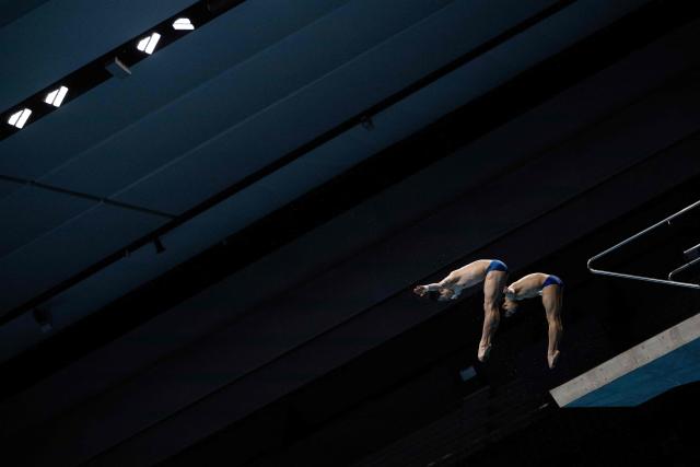 Divers practice in between swimming events during the 2026 Asian Games at the Tokyo Aquatics Centre in Tokyo on September 25,  2026. (Photo by ANDREW CABALLERO-REYNOLDS / AFP)