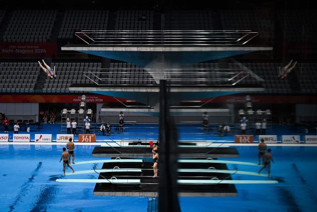 TOPSHOT - Divers practice in between swimming events during the 2026 Asian Games at the Tokyo Aquatics Centre in Tokyo on September 25,  2026. (Photo by ANDREW CABALLERO-REYNOLDS / AFP)