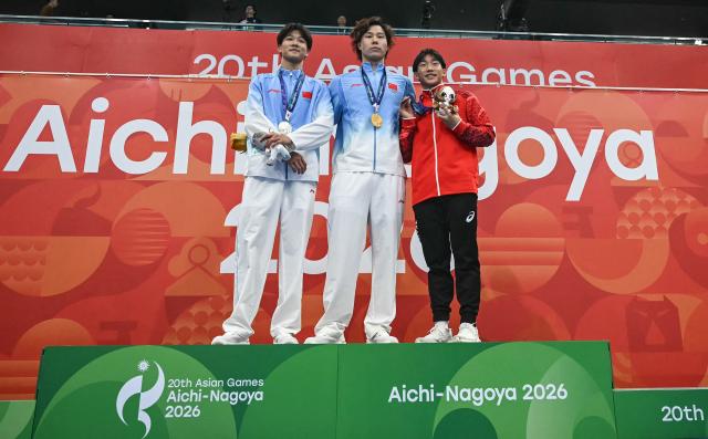 Silver medallist China's Liu Junjie (L), gold medallist China's Qin Haiyang (C) and bronze medallist Japan's Shin Ohashi (R) celebrate on the podium during the victory ceremony of the men's 50m breaststroke swimming event during the 2026 Asian Games at the Tokyo Aquatics Centre in Tokyo on September 25, 2026. (Photo by ANDREW CABALLERO-REYNOLDS / AFP)