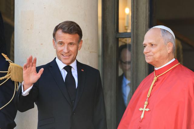 France's President Emmanuel Macron (L) welcomes Pope Leo XIV (R) ahead of a meeting at the Elysee Presidential Palace, in Paris on September 25, 2026 at the start of his four days visit to France. Pope Leo XIV begins an official visit to France on September 25, with several thorny issues hanging over the trip, from clerical sexual abuse to the country's new assisted dying law. (Photo by Ludovic MARIN / AFP)
