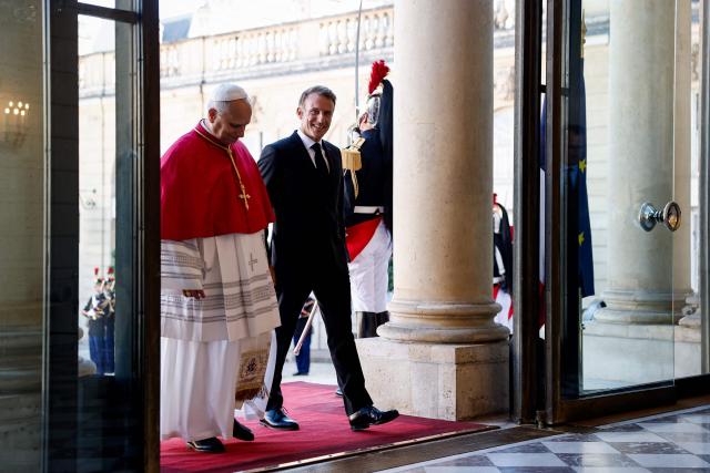 France's President Emmanuel Macron (R) welcomes Pope Leo XIV (L) ahead of a meeting at the Elysee Presidential Palace, in Paris on September 25, 2026 at the start of his four days visit to France. Pope Leo XIV begins an official visit to France on September 25, with several thorny issues hanging over the trip, from clerical sexual abuse to the country's new assisted dying law. (Photo by Benoit Tessier / POOL / AFP)