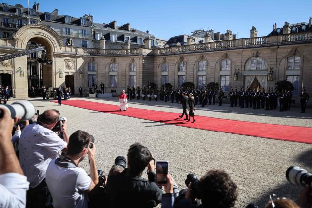France's President Emmanuel Macron (C) and his wife Brigitte welcome Pope Leo XIV (L) ahead of a meeting at the Elysee Presidential Palace, in Paris on September 25, 2026 at the start of his four days visit to France. Pope Leo XIV begins an official visit to France on September 25, with several thorny issues hanging over the trip, from clerical sexual abuse to the country's new assisted dying law. (Photo by Ludovic MARIN / AFP)