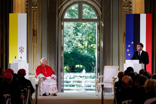 France's President Emmanuel Macron (R) delivers a speech as Pope Leo XIV (L) listens during a ceremony following their meeting at the Elysee Presidential Palace, in Paris on September 25, 2026 at the start of Pope's four days visit to France. (Photo by Benoit Tessier / POOL / AFP)