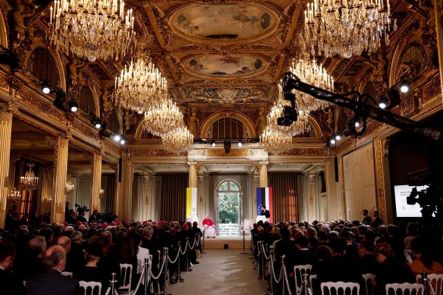 France's President Emmanuel Macron (R) delivers a speech as Pope Leo XIV (L) listens during a ceremony following their meeting at the Elysee Presidential Palace, in Paris on September 25, 2026 at the start of Pope's four days visit to France. (Photo by Benoit Tessier / POOL / AFP)