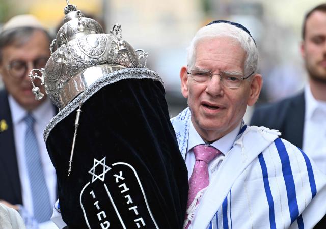 (FILES) The President of the Central Council of Jews in Germany, Josef Schuster carries the Torah scroll during the inauguration ceremony of the rooms of the first military rabbinate of the German Armed Forces Bundeswehr in Berlin, Germany, on July 4, 2024. The main Jewish community group in Germany urged the far-left Die Linke to tackle antisemitism in its ranks as the party seeks to take power in Berlin following an election victory, in an interview with AFP. Josef Schuster, president of the Central Council of Jews, acknowledged the party's lead candidate Elif Eralp had made her opposition to antisemitism clear, but added: "Her stance is obviously not shared within the party she represents in Berlin." (Photo by RALF HIRSCHBERGER / AFP)