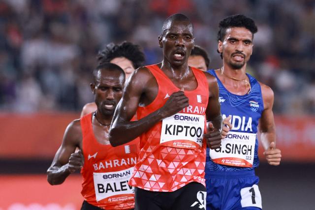 Bahrain's Albert Kiptoo (C), India's Gulveer Singh (R) and Bahrain's Birhanu Balew compete in the men's 10000m final during the 2026 Asian Games at Nagoya City Mizuho Park Athletic Stadium in Nagoya, Aichi Prefecture on September 25, 2026. (Photo by DAVID GRAY / AFP)