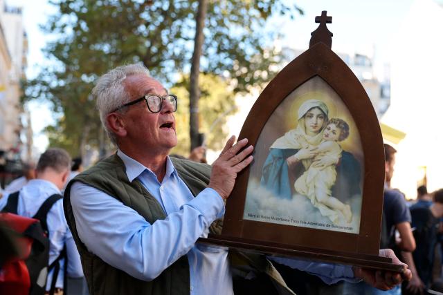 A faithful holds an icon bearing Virgin Mary as he waits for the Pope at Notre Dame des Champs Church in Paris on September 25, 2026 as part of his four days visit to France. (Photo by Anne-Christine POUJOULAT / AFP)