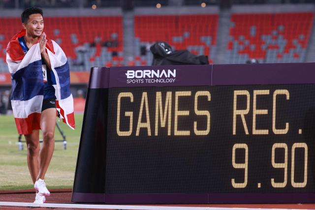 Thailand's Puripol Boonson celebrates beside the time board after setting a new games record in the men's 100m final during the 2026 Asian Games at Nagoya City Mizuho Park Athletic Stadium in Nagoya, Aichi Prefecture on September 25, 2026. (Photo by DAVID GRAY / AFP)