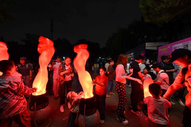 People visit a park during the Mid-Autumn Festival in Beijing on September 25, 2026. (Photo by Adek BERRY / AFP)