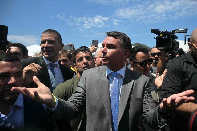Brazil's senator and presidential candidate for the Liberal Party (PL) Flavio Bolsonaro (C) and state deputy and candidate for governor of Rio de Janeiro state Douglas Ruas (2nd L) leave after a graduation ceremony at the Center of Improvement and Training of Soldiers (CFAP) at Sulacap neighbourhood in Rio de Janeiro, Brazil, on September 25, 2026. Brazil will hold presidential election on October 4, 2026. (Photo by MAURO PIMENTEL / AFP)