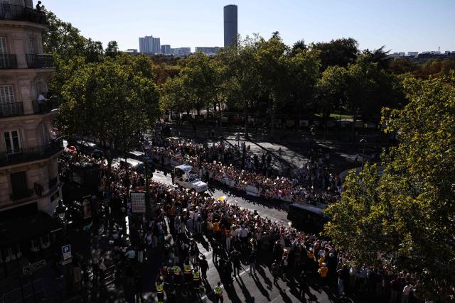 TOPSHOT - Pope Leo XIV waves to the crowd while riding in the Papamobile (popemobile) on a street, as the Montparnasse tower is seen in the background in Paris on September 25, 2026 as part of his four days visit to France. (Photo by SIMON WOHLFAHRT / AFP)