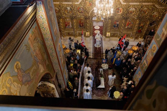 Relatives and friends mourn around the coffin of Mykola Karpyuk, a Ukrainian serviceman, public and political figure and former political prisoner of the Kremlin who was killed in combat during the Russian invasion of Ukraine, at a funeral ceremony in Kyiv on September 25, 2026. (Photo by Tetiana DZHAFAROVA / AFP)