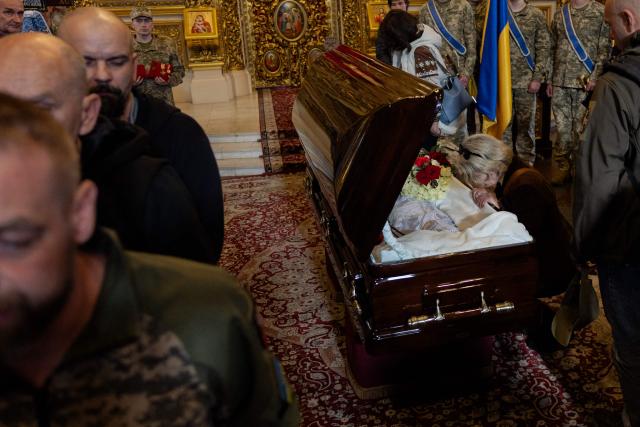 Relatives and friends mourn around the coffin of Mykola Karpyuk, a Ukrainian serviceman, public and political figure and former political prisoner of the Kremlin who was killed in combat during the Russian invasion of Ukraine, at a funeral ceremony in Kyiv on September 25, 2026. (Photo by Tetiana DZHAFAROVA / AFP)