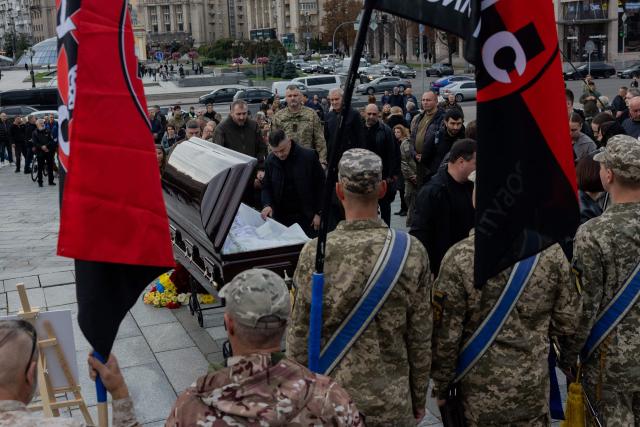 Relatives, friends and mourners pay they repsects at the coffin of Mykola Karpyuk, a Ukrainian serviceman, public and political figure and former political prisoner of the Kremlin who was killed in combat during the Russian invasion of Ukraine, during a funeral ceremony in Kyiv on September 25, 2026. (Photo by Tetiana DZHAFAROVA / AFP)