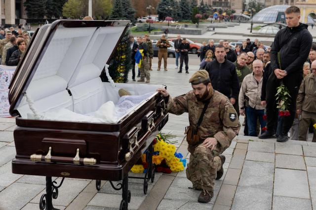 Relatives, friends and mourners pay they repsects at the coffin of Mykola Karpyuk, a Ukrainian serviceman, public and political figure and former political prisoner of the Kremlin who was killed in combat during the Russian invasion of Ukraine, during a funeral ceremony in Kyiv on September 25, 2026. (Photo by Tetiana DZHAFAROVA / AFP)