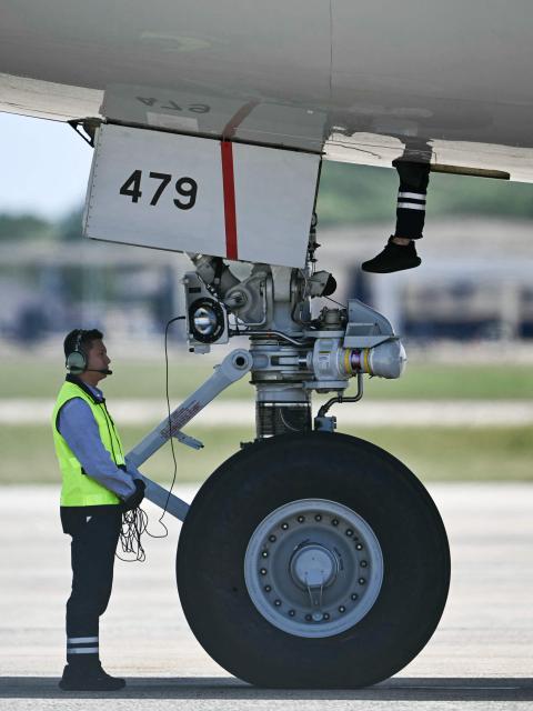 A crew member climbs into the plane as China's President Xi Jinping and his wife Peng Liyuan prepare to depart on an Air China plane at Joint Base Andrews in Maryland on September 25, 2026. President Xi was on a state visit to the United States from September 23 to 25. (Photo by Kent NISHIMURA / AFP)