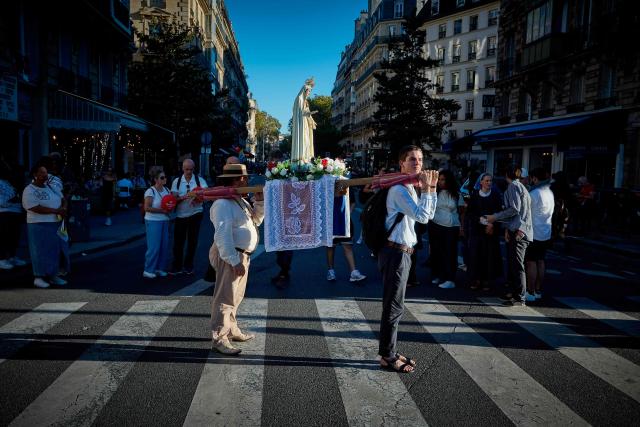 Pilgrims for Britanny carry a statue of the Virgin Mary near Notre-Dame Cathedral, where Pope Leo XIV presides Solemn Vespers in Paris on September 25, 2026 as part of his four days visit to France. (Photo by Kiran RIDLEY / AFP)